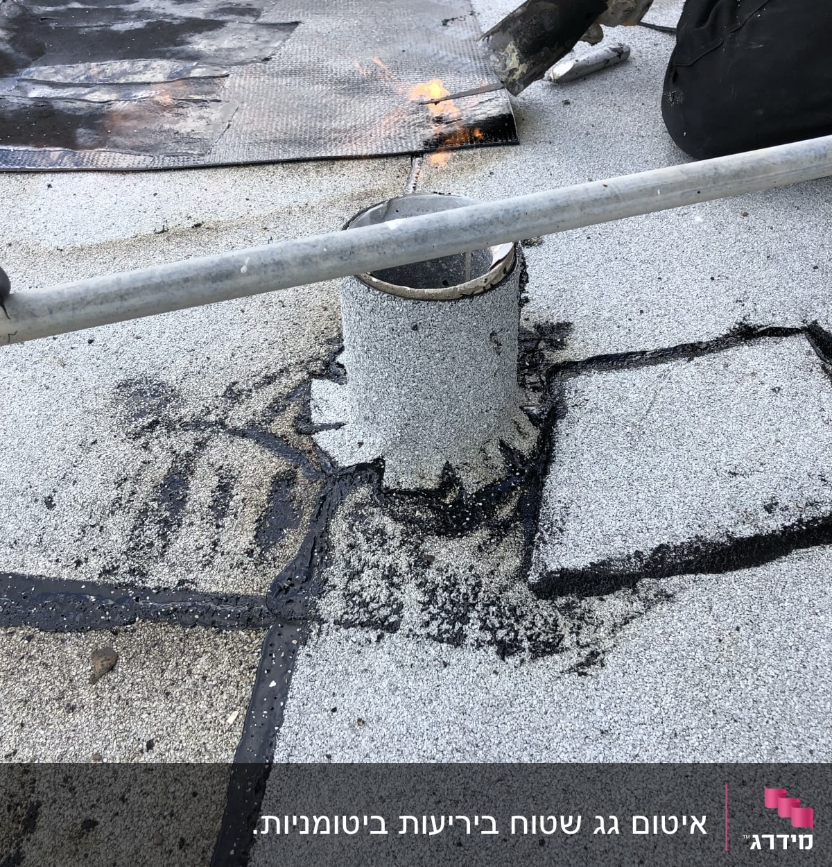אדם משתמש במבער לאיטום גג עם יריעות ביטומניות